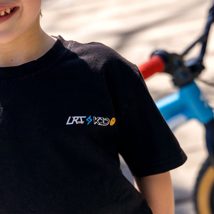 Close-up of the LRT x K1D logo on the front left chest area of the tee