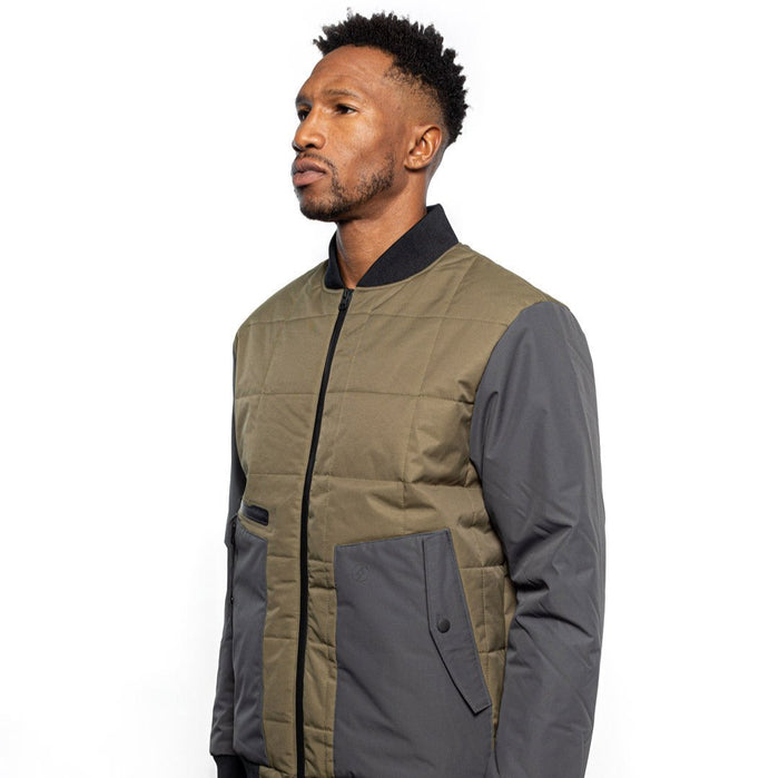 Side view of Male model wearing Sipes Varsity Jacket in dark fatigue colorway. @color_dark fatigue