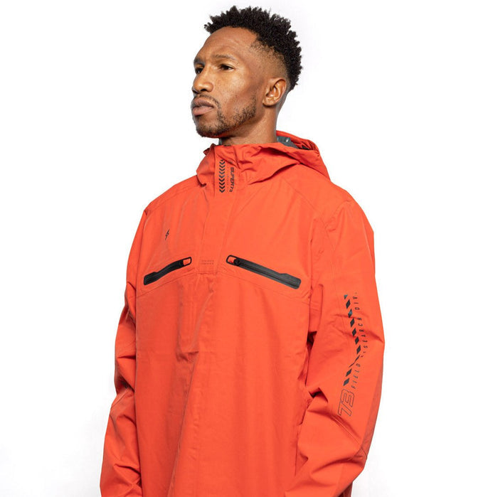 Side view of Male model wearing Vale Packable Anorak in blood orange colorway. @color_blood orange