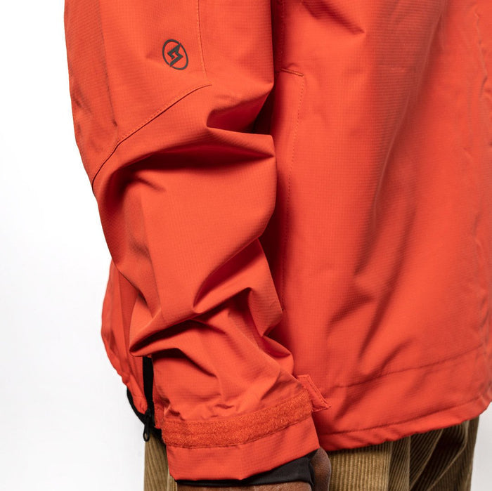 Side sleeve detail shot of male model wearing Vale Packable Anorak in blood orange colorway. @color_blood orange