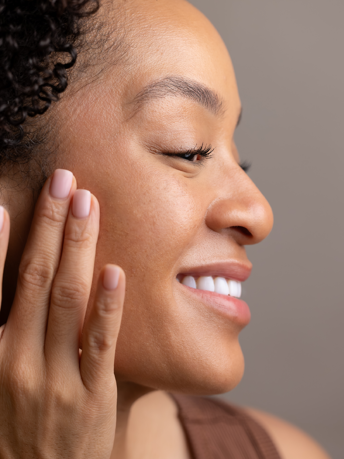 Woman applying Vitamin C Face Serum for dull skin, dark spots, and uneven skin tone.